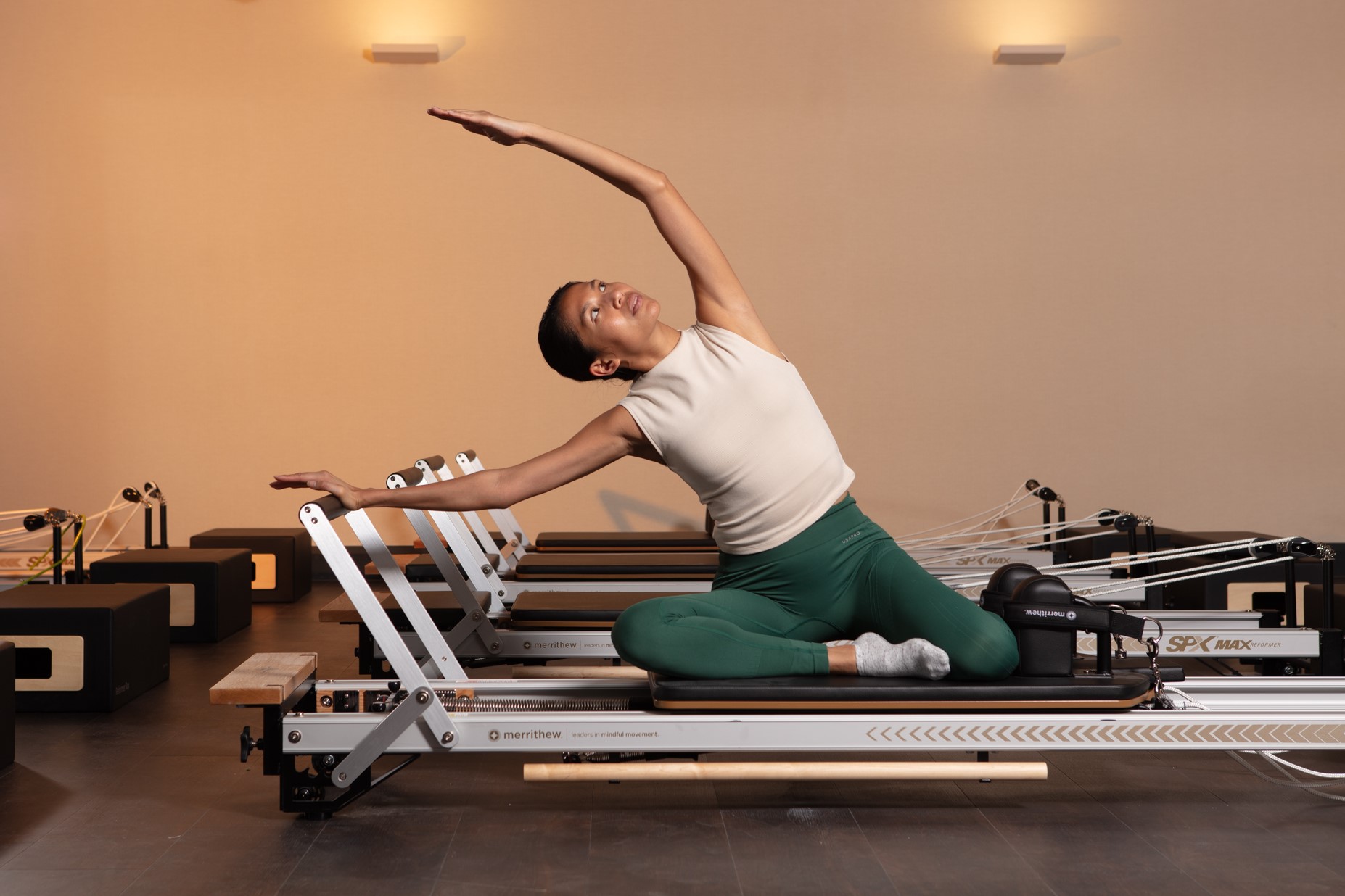 Man at the front of a Reformer Pilates class